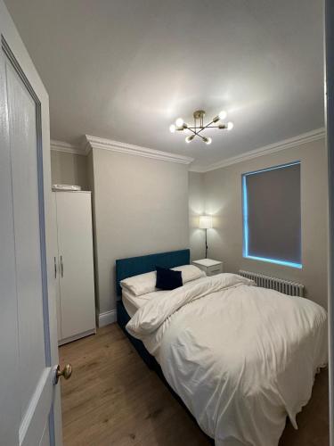 a bedroom with a bed and a ceiling fan at Stylish Four-Bed Haven Near Greenwich in Plumstead