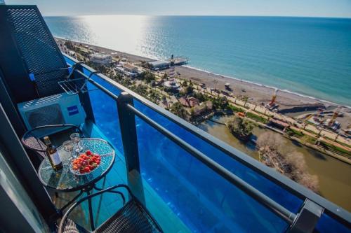 a table on a balcony with a view of the beach at BATUMI ORBI APARTMENTs in Angisa