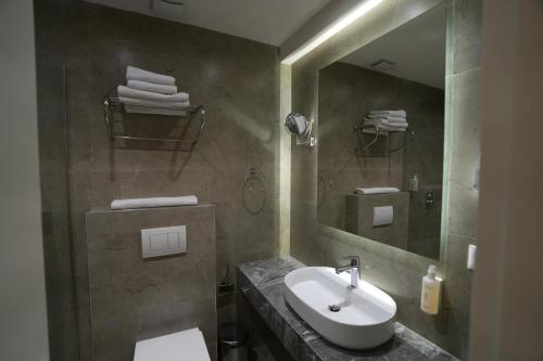 a bathroom with a sink and a mirror at Avdissons Hotel in Prizren