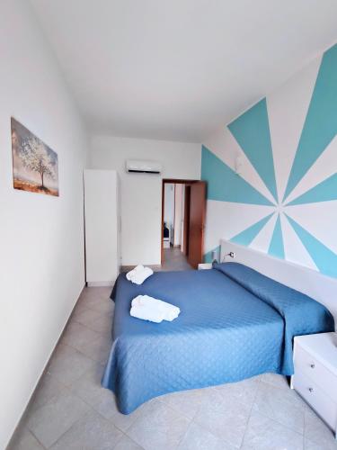 a bedroom with a blue bed in a room at Villa Anita Apartments in Capo dʼOrlando