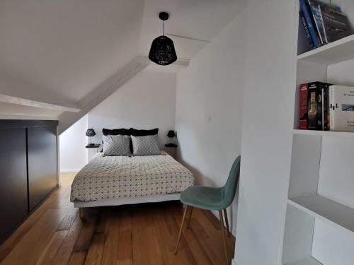 - une chambre avec un lit et une chaise verte dans l'établissement Charmant appartement vue sur le port de Dahouet, à Pléneuf-Val-André