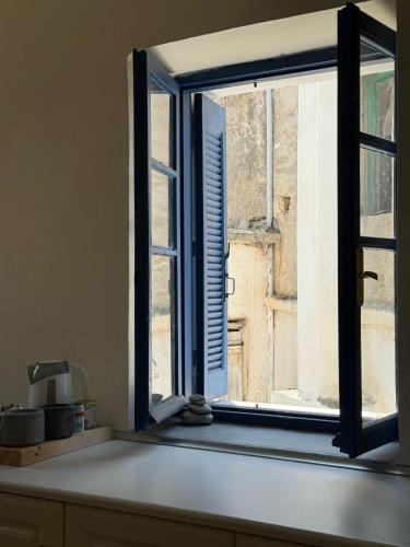 an open window with a view of a building at iris house in Kalo Chorio