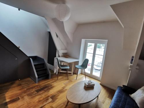 un salon avec une table et des chaises dans l'établissement Charmant appartement vue sur le port de Dahouet, à Pléneuf-Val-André