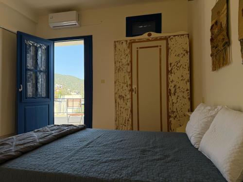 a bedroom with a bed and a door with a window at iris house in Kalo Chorio