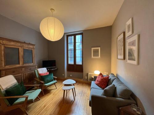 a living room with a couch and a table at Appartement centre ville de Bourg d'Oisans in Le Bourg-dʼOisans