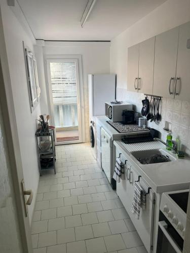 une cuisine blanche avec une cuisinière et un évier dans l'établissement logement 1 chambres, à Cannes