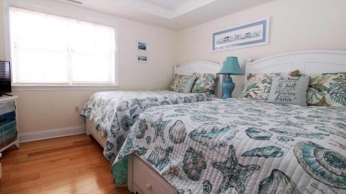 a bedroom with two beds and a television at Broadway Beach Unit 7 in Cape May
