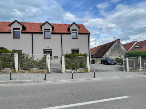 a white house with a red roof on a street at Smart Stay Apartment Samobor in Samobor