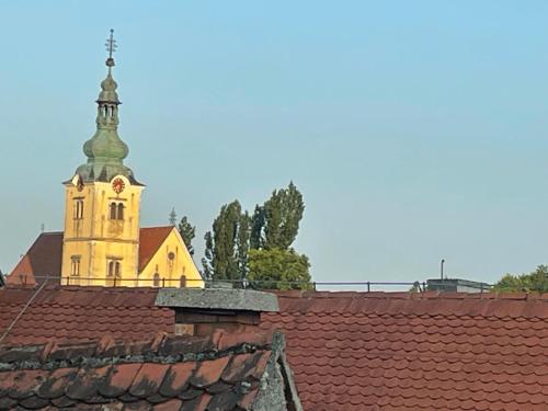 a church with a clock tower on top of a roof at Smart Stay Apartment Samobor in Samobor