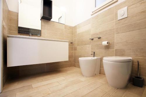 a bathroom with a white toilet and a sink at Villa Sa Marchesa in Solanas