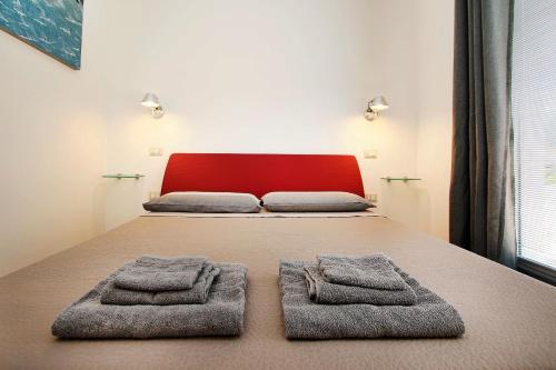 a bedroom with a bed with two towels on it at Villa Sa Marchesa in Solanas