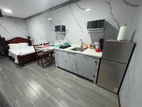 a kitchen with a sink and a refrigerator and a bed at Apartamento doña Lety in Fortuna