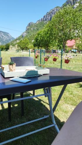 a picnic table in front of a field with a fence at Home Delic Komarnica in Šavnik
