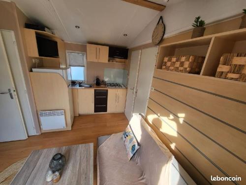 a living room with a couch and a kitchen at Mobil home, camping les pins maritimes in Hyères
