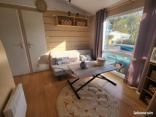 a living room with a coffee table and a window at Mobil home, camping les pins maritimes in Hyères