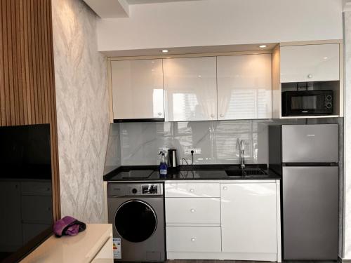 a kitchen with white cabinets and a dishwasher at venus apart hotel in Batumi