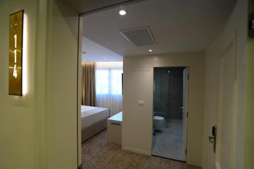 a bathroom with a tub and a toilet and a mirror at Avdissons Hotel in Prizren