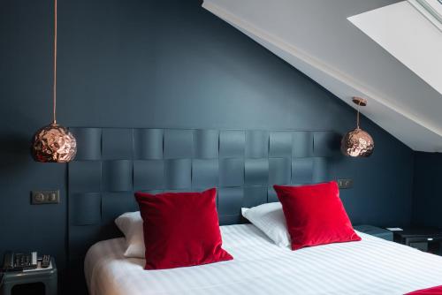 a bedroom with a bed with red pillows at Saint Georges Hotel & Spa in Chalon-sur-Saône