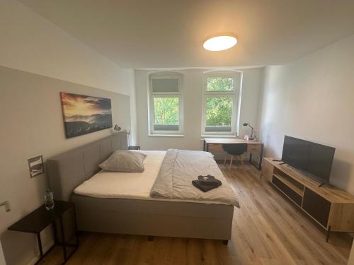 a bedroom with a bed and a desk and a television at Wohlfühl-Oase in Herne