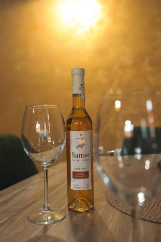 a bottle of wine sitting next to a wine glass at Apartmani Kačara in Sremski Karlovci