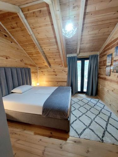 a bedroom with a bed in a wooden cabin at Villa Butterfly Valdanos in Ulcinj