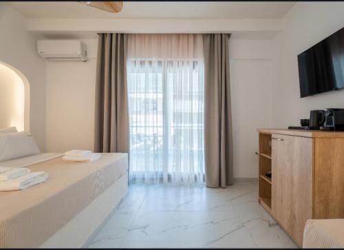 a hotel room with a bed and a large window at Meltemi Marmaras in Neos Marmaras