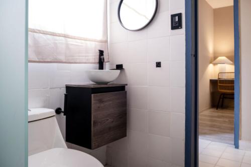 a bathroom with a toilet and a sink and a mirror at AmazINN Collection CDMX Insurgentes in Mexico City
