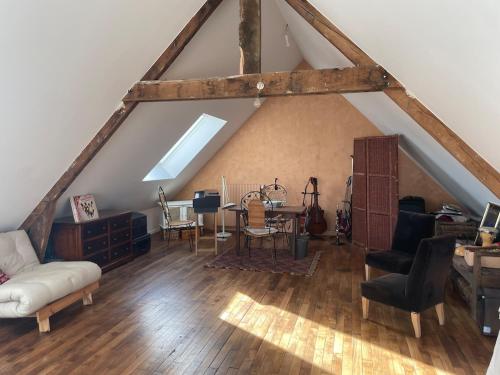 Cette chambre mansardée comprend une table et des chaises. dans l'établissement Jolie maison de village proche de la mer, à Clohars-Fouesnant