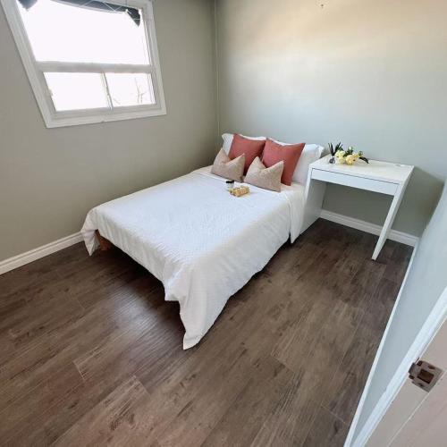 a bedroom with a bed with a table and a window at Nest in the Orchard--cozy room in Toronto