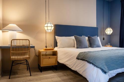 a bedroom with a bed and a chair and lights at AmazINN Collection CDMX Insurgentes in Mexico City