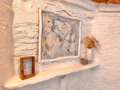 a wall with a picture and a vase on a shelf at Aikkya Farms in Mukteswar