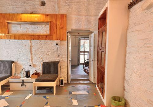 a hallway with two chairs and a table in a room at Aikkya Farms in Mukteswar