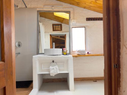 a white table with a cake on it in a bathroom at Aikkya Farms in Mukteswar
