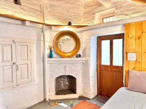 a living room with a fireplace and a mirror at Aikkya Farms in Mukteswar