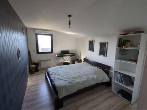 une chambre avec un lit et un bureau dans l'établissement Maison de famille, 5min des plages, à Saint-Alban