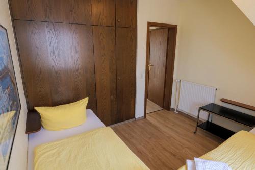 a bedroom with two beds and a wooden wall at Appartementhaus Alt Büsum in Büsum