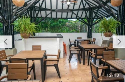 a restaurant with wooden tables and chairs and plants at El Tesoro - Finca Hotel Eje Cafetero in Calarcá