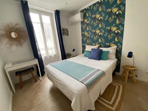 une chambre avec un grand lit avec un mur bleu dans l'établissement 2 pièces hyper centre, à Nice