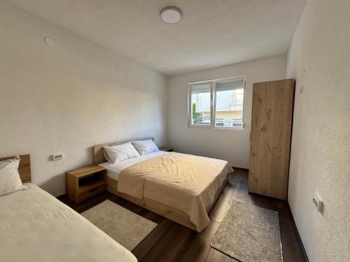 a small bedroom with two beds and a window at Teona Apartment in Ohrid