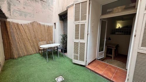 a small patio with a table and chairs in a room at Studio Carré d 'Or - 5 minutes de la mer in Nice