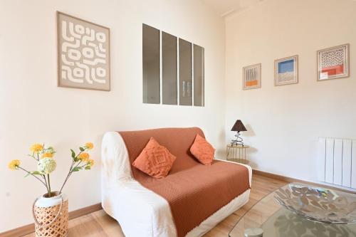 un salon avec un canapé et une table dans l'établissement T2 cosy avec clim cour Charme & fraîcheur à Nîmes, à Nîmes