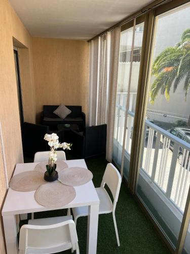 Cette chambre dispose d'un balcon avec une table et des chaises blanches. dans l'établissement Logements centrale, à Cannes