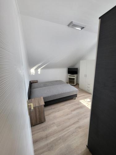 a bedroom with a bed and a wooden floor at Csalogány Apartman in Mezőkövesd