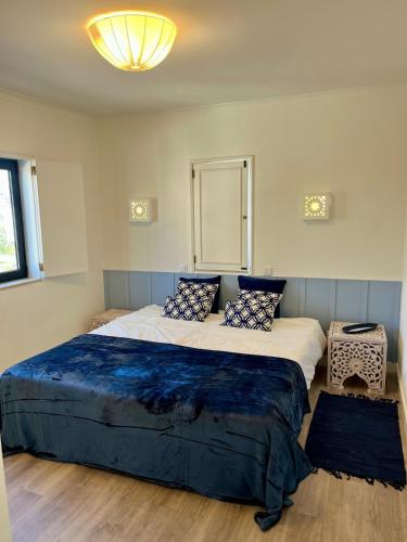 a bedroom with a large bed with blue pillows at Delta Marina Vilamoura in Quarteira