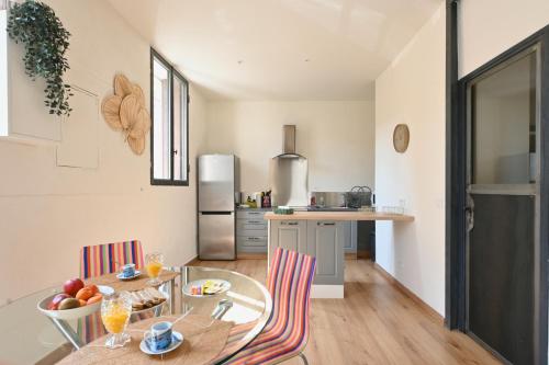 une cuisine avec une table et des chaises ainsi qu'une salle à manger dans l'établissement T2 cosy avec clim cour Charme & fraîcheur à Nîmes, à Nîmes