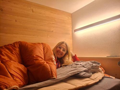 a woman laying on a bed in a room at Inner Holiday Dolomites 5 in Dimaro