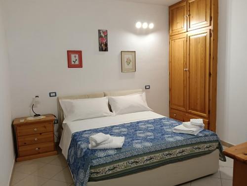 Un dormitorio con una cama y un armario de madera. en L'orchidea, en Tortolì