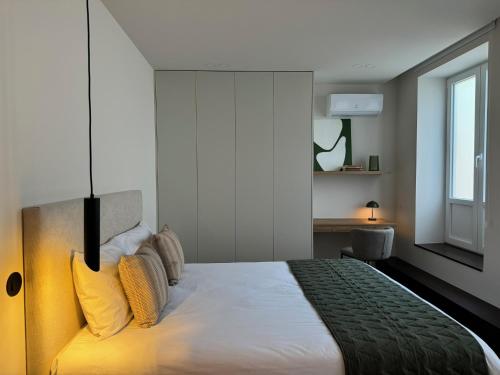a bedroom with a large white bed with yellow pillows at Apartamento do Ferreiro in Ponte da Barca