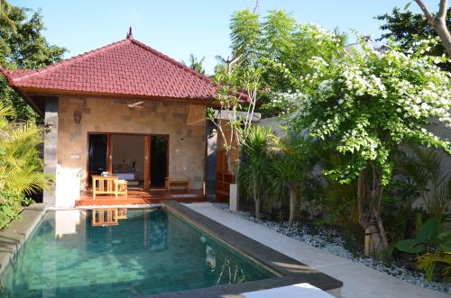 a villa with a swimming pool in front of a house at Taman Senang - Private Pool Villas - Gili Air in Gili Air