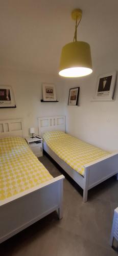 two beds sitting in a room with a light at Domus Lapidea in Postira